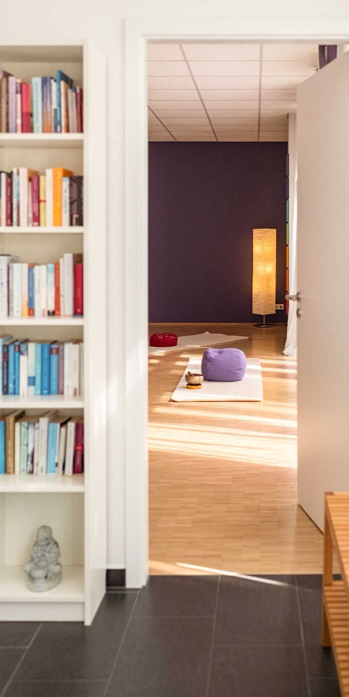 Blick in den YogaRaum Bergisch Gladbach mit Bücherregal und Tageslicht